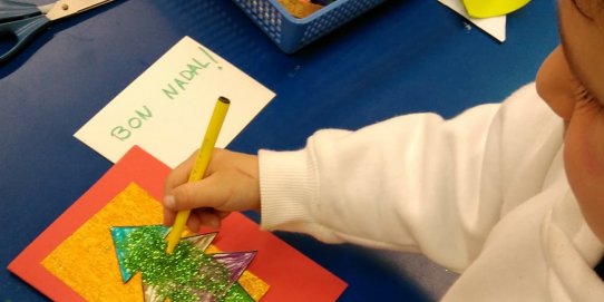 Un infant, elaborant la seva postal de Nadal.
