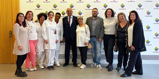 El regidor Rubén Peñalver, el propietari de Càrniques Merche i president del Gremi de Carnissers de Barcelona, Antonio Gálvez, amb les tres persones participants del curs i altres assistents.