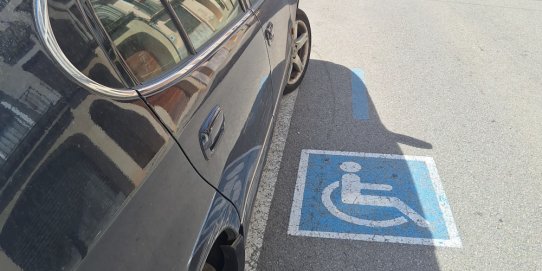 Imatge d'un vehicle estacionat en una plaça PMR.